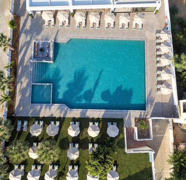 Aerial view of the large outdoor pool area with sunbeds and firepit lounge 