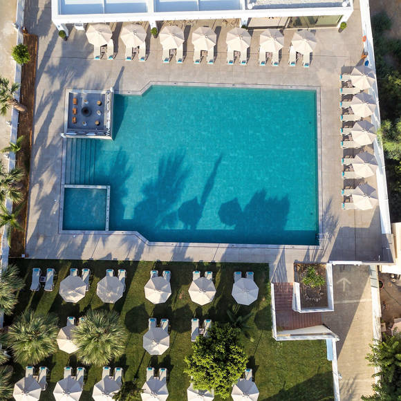 Aerial view of the large outdoor pool area with sunbeds and firepit lounge 