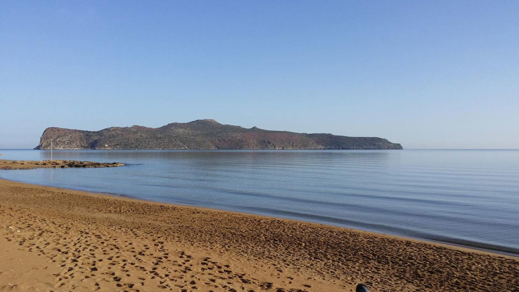 The sandy beach near the Dore Hotel with a view of Thodorou Island 
