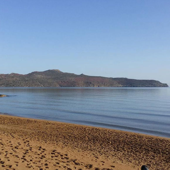 The sandy beach near the Dore Hotel with a view of Thodorou Island 