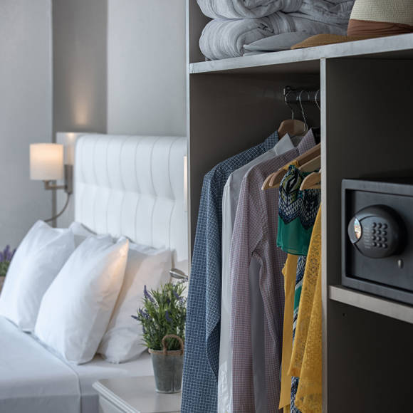 Close-up of wardrobe with hanging clothes and a safe