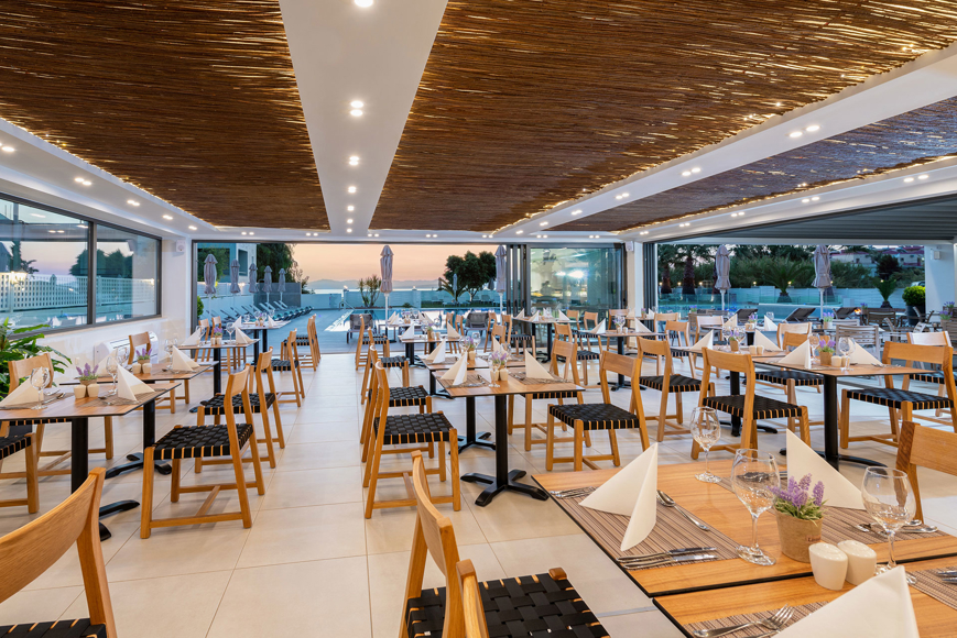 Modern hotel restaurant with set tables and a view of the pool area