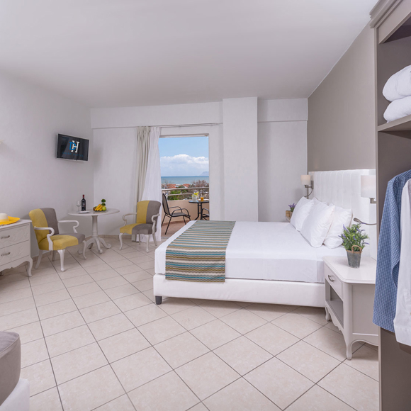 Double room with sea view, open wardrobe and cozy seating area