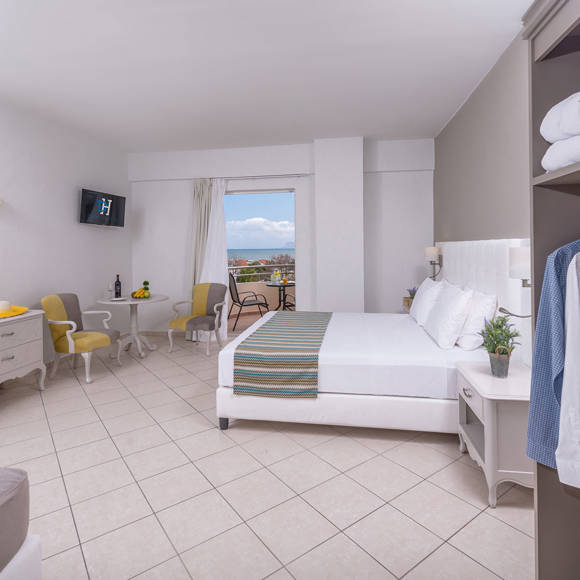 Double room with sea view, open wardrobe and cozy seating area