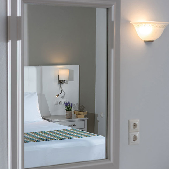 Elegant mirror showing bed and bedside lighting 