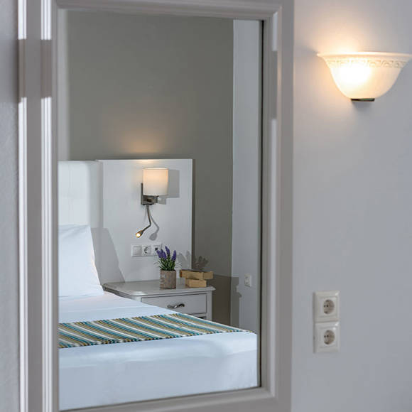 Elegant mirror showing bed and bedside lighting 