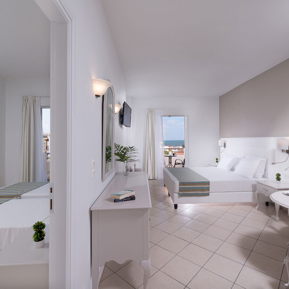 Wide view of the two bedroom family room, featuring a main double bed and a separate area with twin beds.