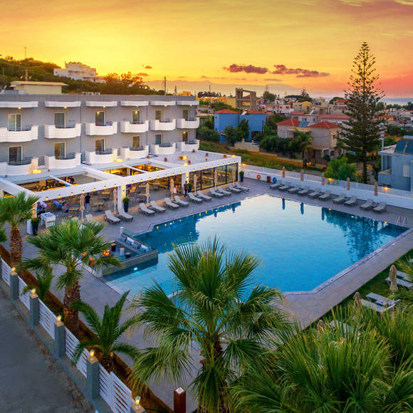 Aerial view of Dore Hotel at dusk near the beach with Thodorou Island in the background