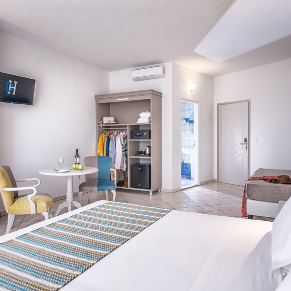 Double room with sitting area, open wardrobe, and view of the entrance and bathroom