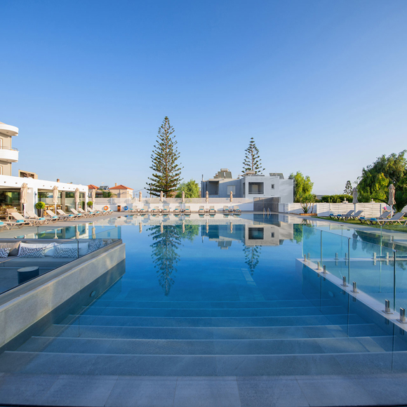 Large outdoor pool with sunbeds and surrounding garden