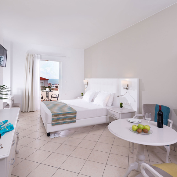 Family room with double bed, open wardrobe and balcony access with sea view