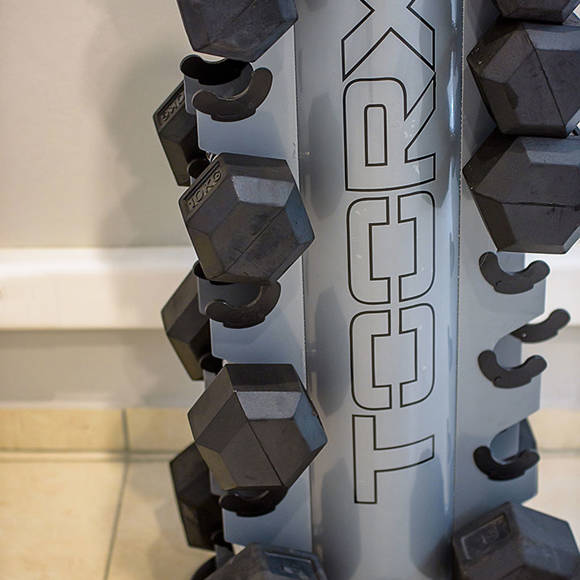 Set of black dumbbells on a metal rack 